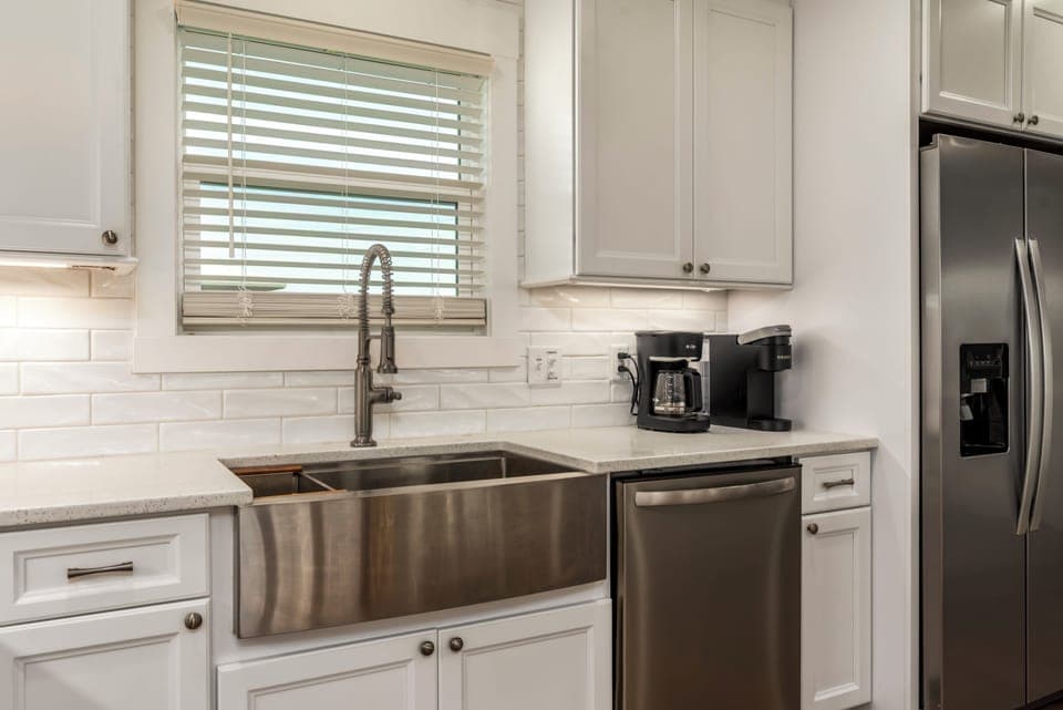 Your bright, fully-equipped kitchen features gleaming stainless appliances and a spacious farmhouse sink perfect for preparing meals together.