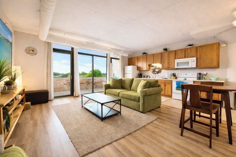 Sun-filled open living space with comfortable seating, full kitchen, and patio access. Natural light, warm finishes, and an inviting layout create the perfect place to relax after exploring the area.