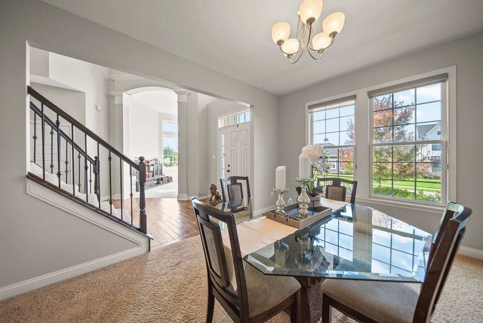 Dining area w/ table, chandelier & large windows for shared meals