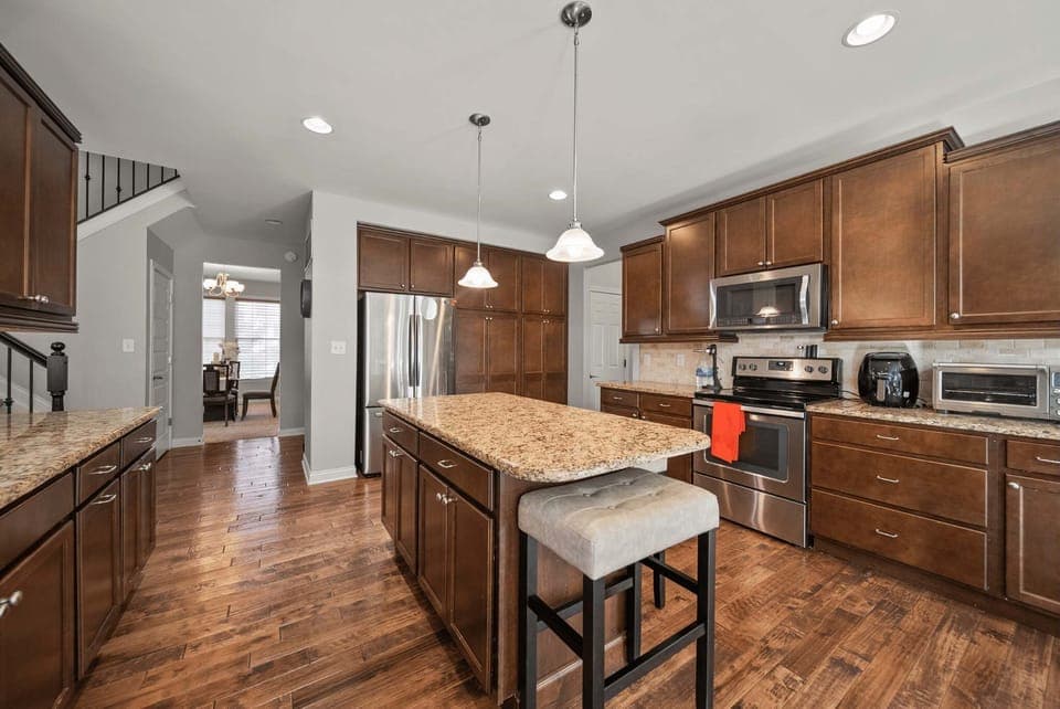 Spacious kitchen w/ large island, wood cabinetry & open layout for cooking together