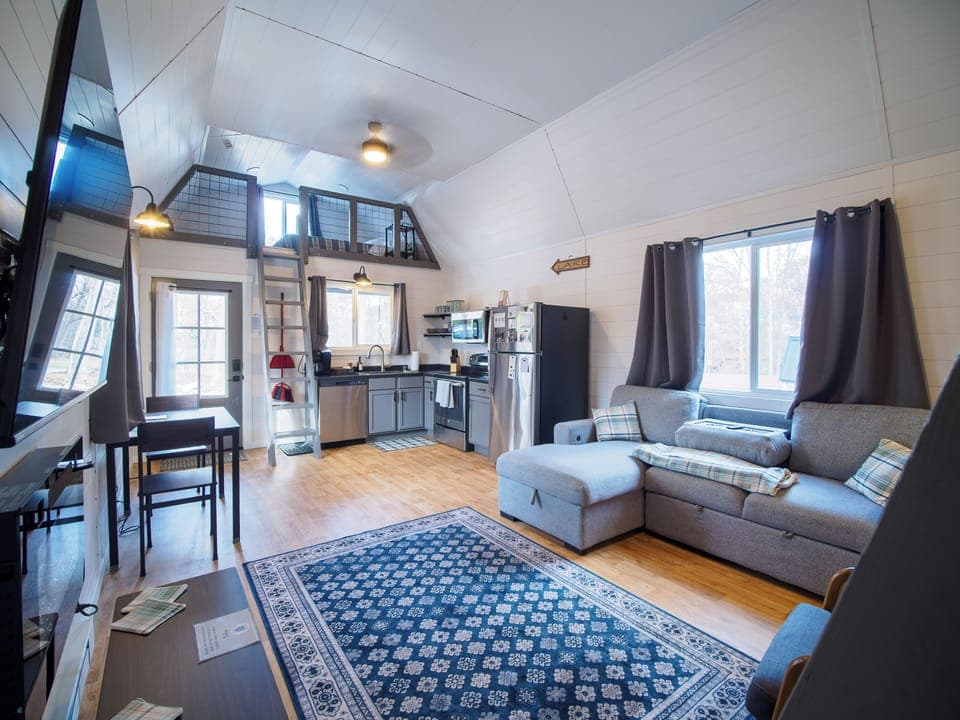 Open-concept kitchen/dining/living room.  Living room features queen sofa bed