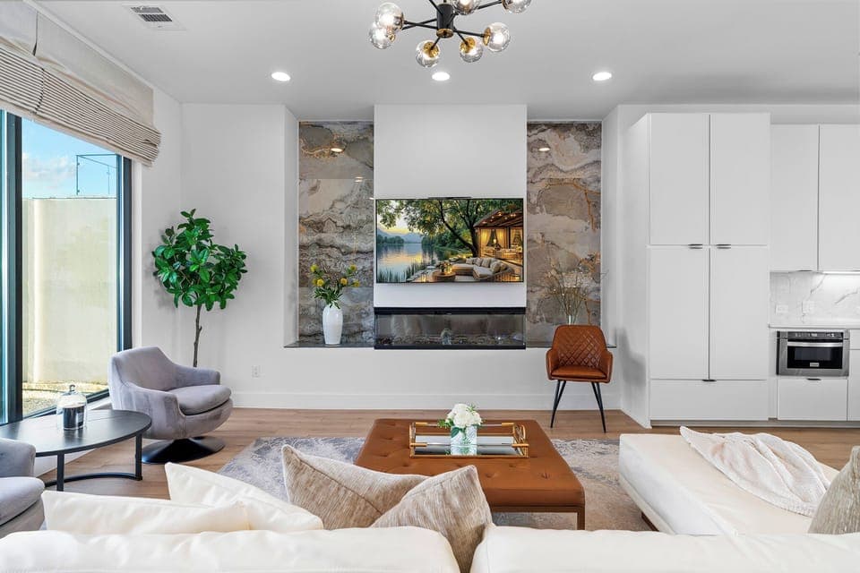 Open living space with TV, electric fireplace and comfy seating - designed for comfort, connection, and conversation