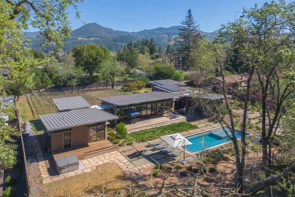 Modern luxury estate nestled in scenic mountain valley with swimming pool and expansive outdoor living spaces.