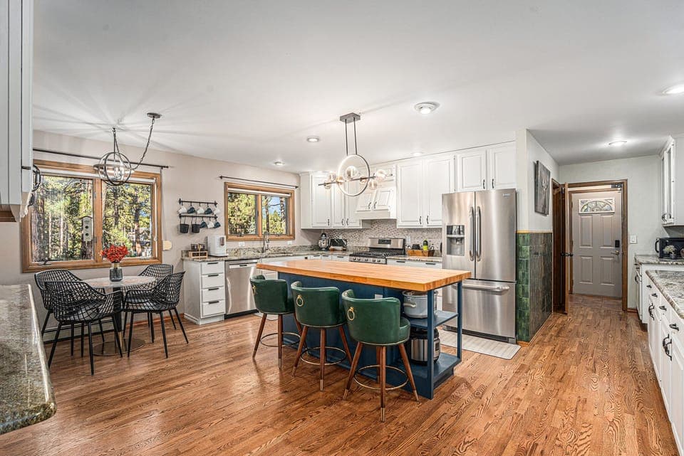 This bright, open kitchen invites everyone to gather, with a spacious island, cozy breakfast nook, and forest views that make cooking, dining, and connecting feel effortless throughout your mountain stay.