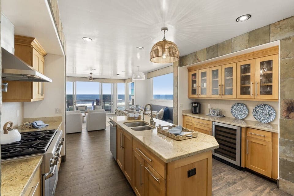 “Bright coastal kitchen with ocean views—cook while watching surfers roll by