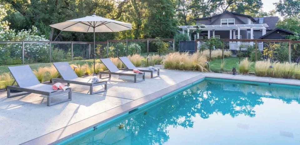 Sun-drenched poolside oasis with lounge seating and serene garden views - perfect for slow mornings, afternoon dips, and golden-hour relaxation.