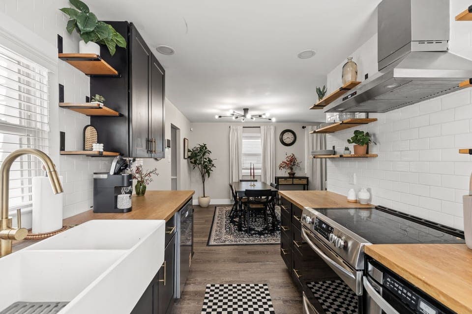 Our bright and modern kitchen with tons of counter space, open shelving, and an easy flow into the dining area for meals and memories.