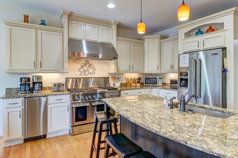 Kitchen - Main-level kitchen with island, stools, and gas range, where all the cooking happens.