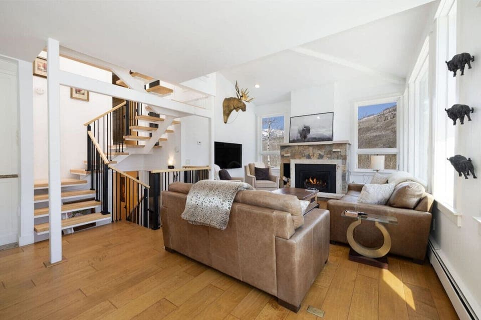Stunning open-concept living room with epic Gore Range views, fireplace, Smart TV, and expansive windows that fill the space with natural light