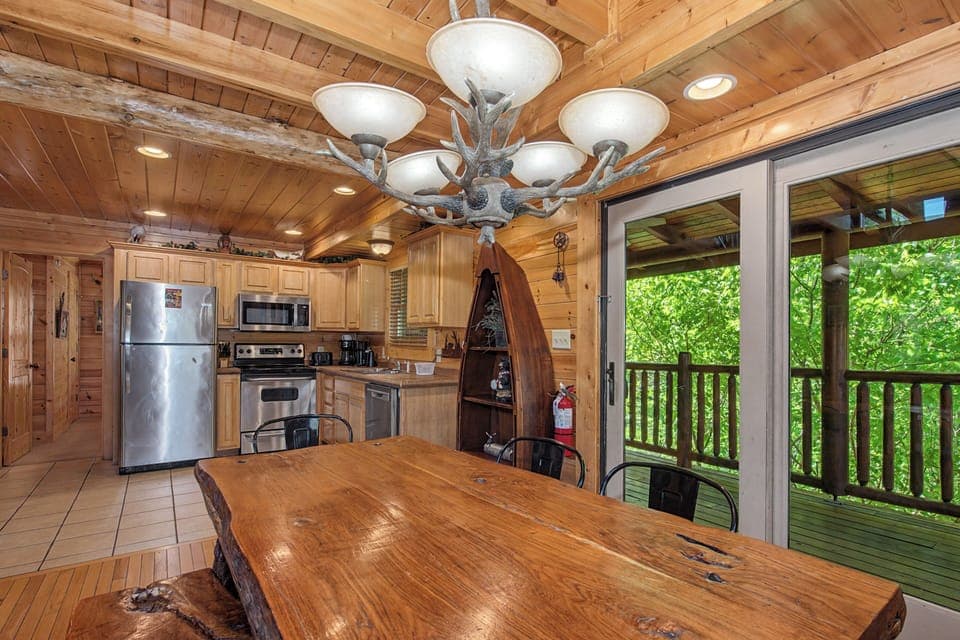 Your rustic kitchen beckons with warm wood throughout, modern appliances, and forest views through sliding doors to your private deck.