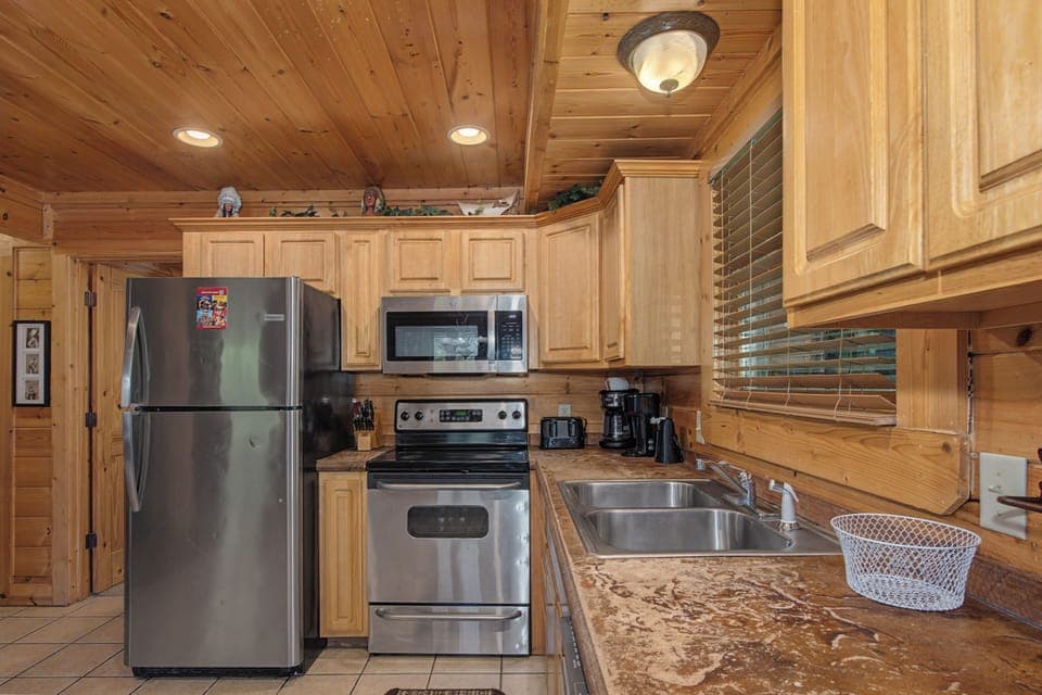 Your fully equipped kitchen features stainless steel appliances and warm wood cabinetry, perfect for preparing family meals during your mountain getaway.