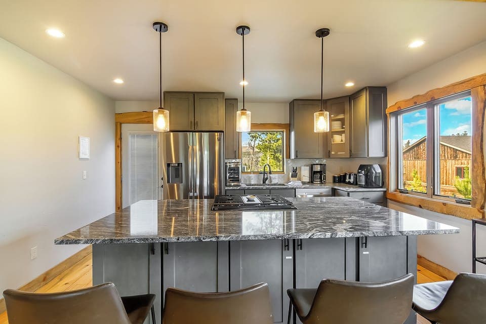 Your chef's dream awaits—gleaming granite counters, premium stainless appliances, and pendant lighting create the perfect culinary haven.