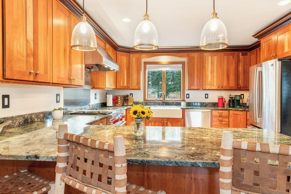 You'll love cooking in this stunning kitchen with granite counters, warm wood cabinets, and pendant lighting creating the perfect culinary space.