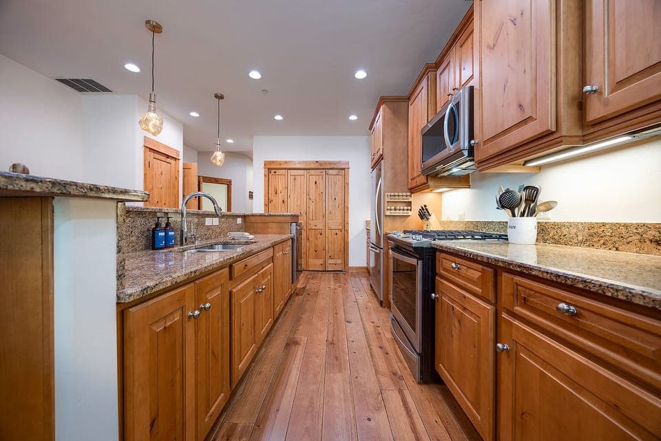 Cook your favorite meals in this spacious gourmet kitchen featuring granite countertops, stainless steel appliances, and warm wood cabinetry.