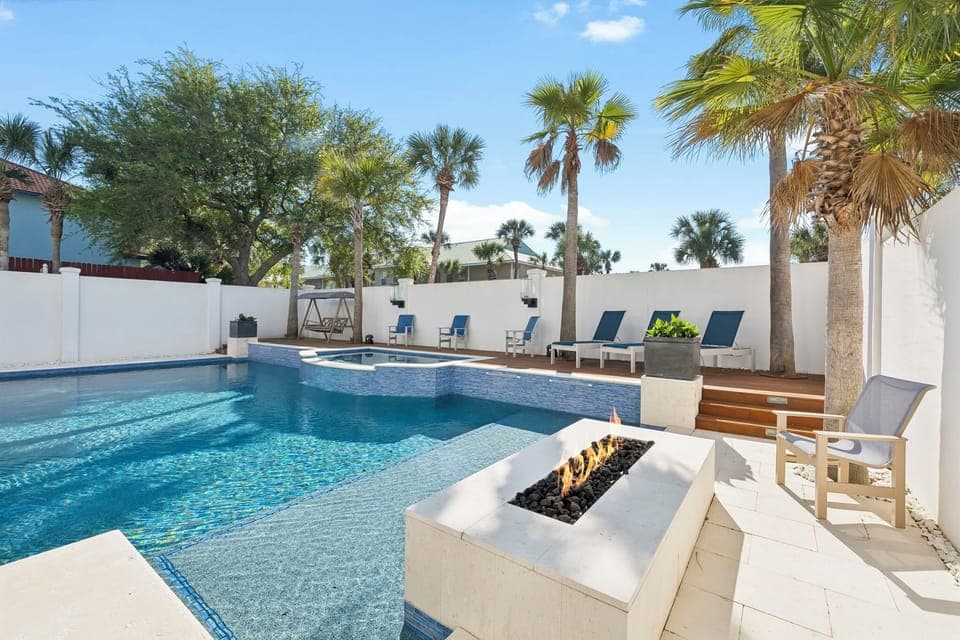 Your private poolside paradise awaits with crystal-clear water, cozy fire feature, and swaying palms creating the perfect tropical escape.