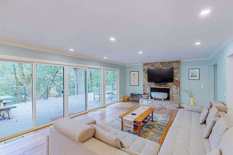Sink into the oversized sectional and plan tomorrow's vineyard itinerary — your living room features a wall of glass opening to the deck, stone fireplace accent, and a large flat-screen TV.