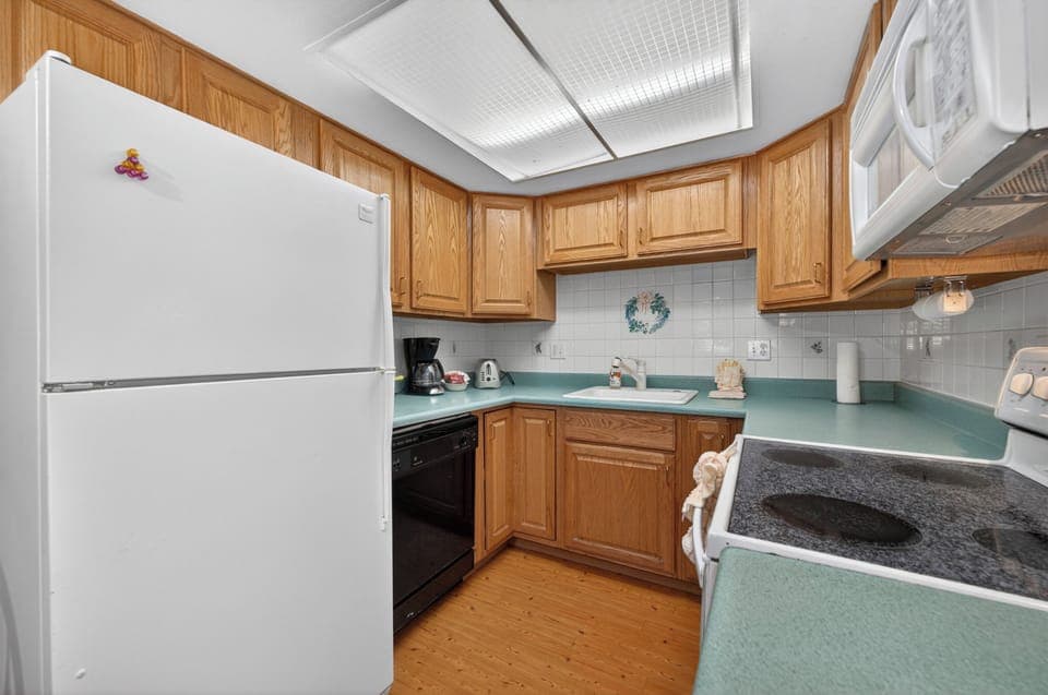 Cook your favorite meals in this fully-equipped kitchen with modern appliances, ample counter space, and warm wood cabinetry that makes you feel right at home.