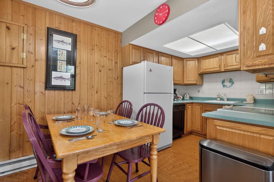 Your fully-equipped kitchen and dining space awaits, where warm wood tones and cheerful accents set the stage for shared meals and memorable conversations around the welcoming table.
