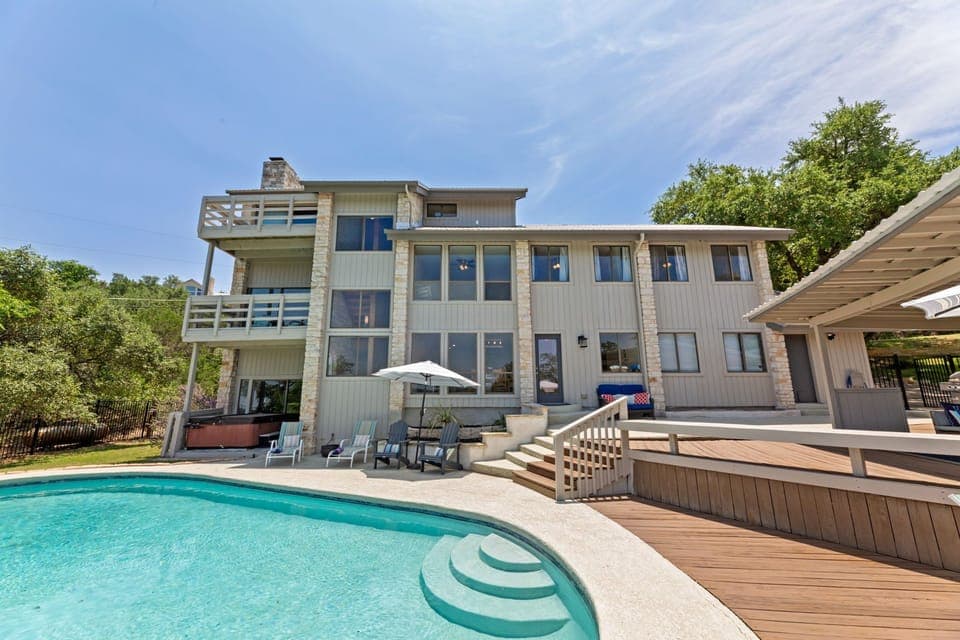 Rear view with large pool and covered patio area. Hot tub, pool basket ball hoop