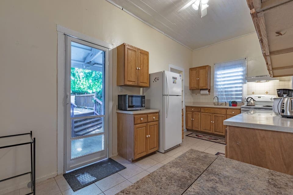 Kitchen leads to outside fenced backyard.