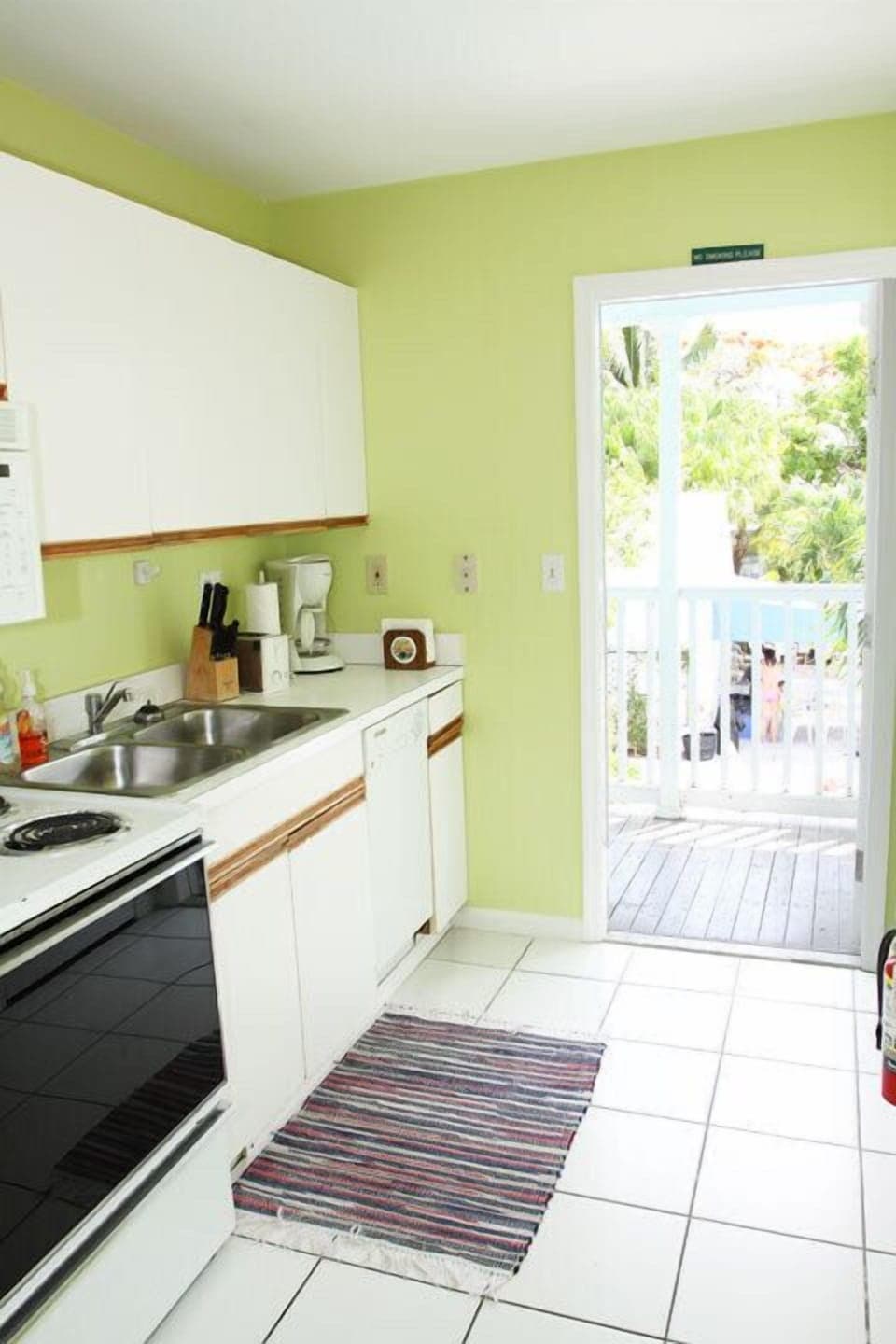 Full size kitchen leads to front balcony overlooking the pool.