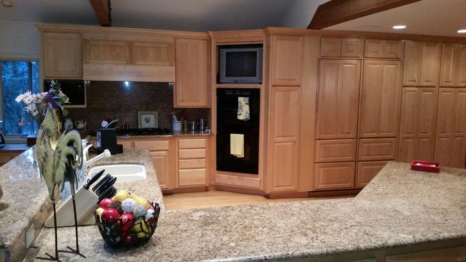 Kitchen view of double oven, large chef's cook to and large granite counter