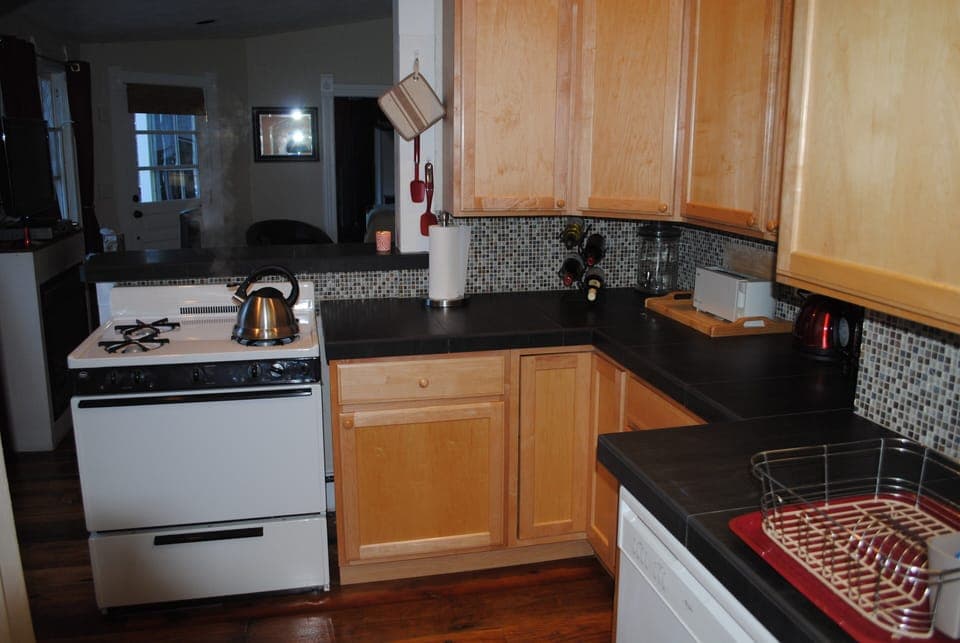 The kitchen adjoins the living room with comfortable sofa and high top table 