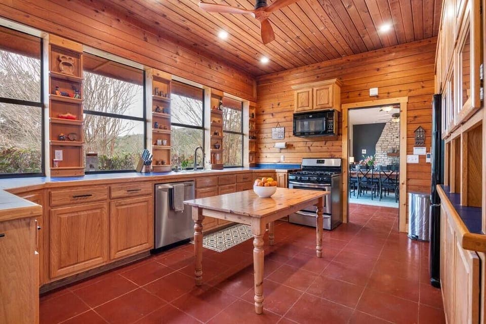 Custom kitchen with gas range, dishwasher, microwave and one of two full fridges.