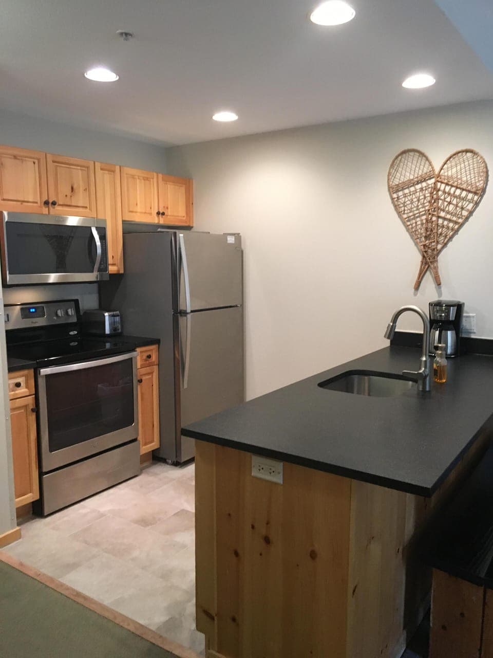 Kitchen with stainless steel appliances & leathered granite countertops.
