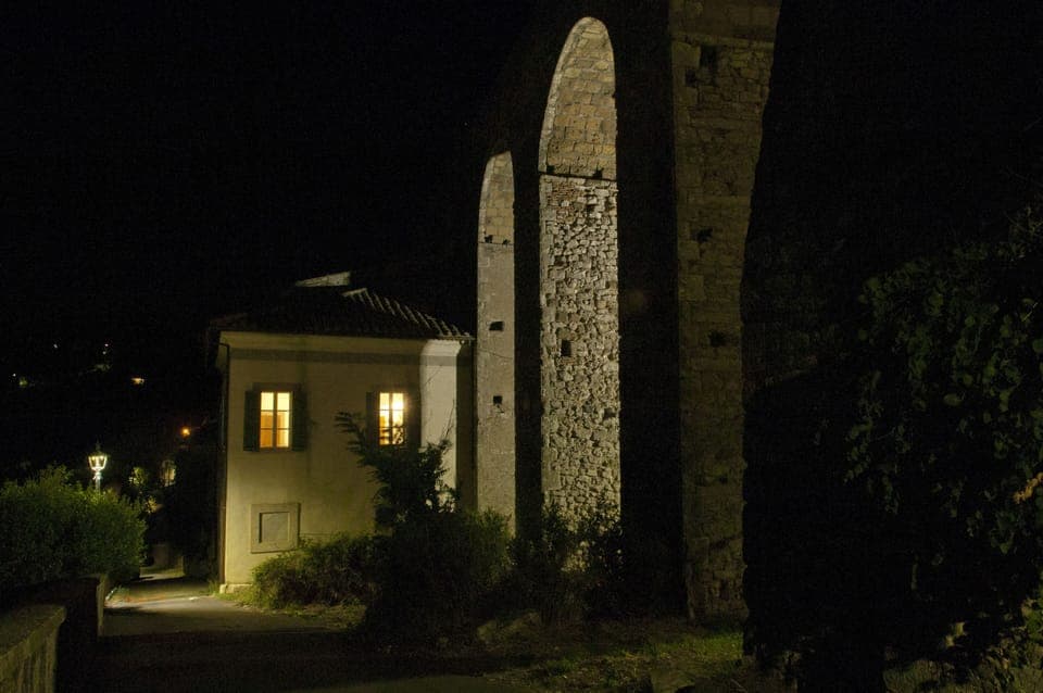 Night photo of the villa and its aqueduct