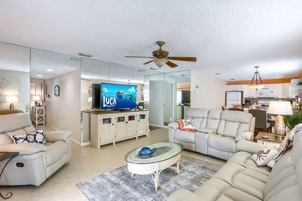 Living Room Offers a Leather Reclining Sofa, Loveseat, Armchair, and a Large Flat Screen TV