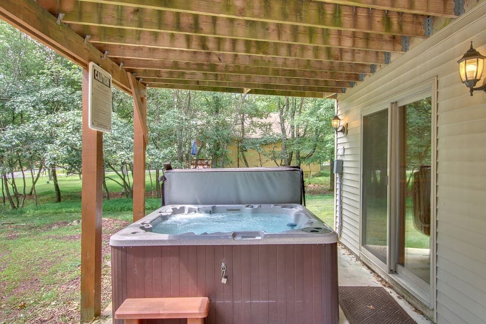 A picture of the outdoor hot tub, powered on with water in it, on the back porch.