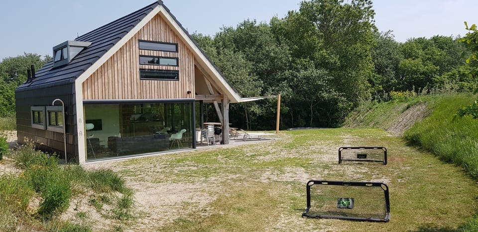 Sporty paradise surrounded by dunes with a trampoline and soccer goals