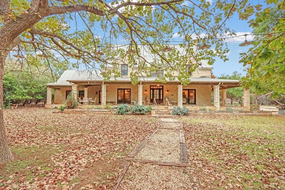 Charming stone and brick ranch-style property surrounded by mature trees and natural landscaping - Main House