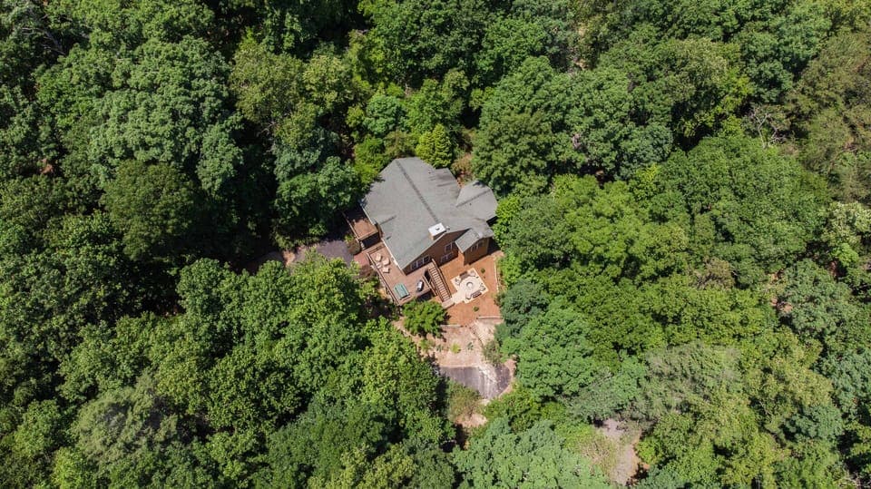 Aerial 2 - Moose Tracks is in a private, wooded setting, but just a few minutes from the heart of Rumbling Bald  pools, beach and other amenities