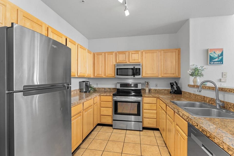 Full kitchen with stainless steel appliances and breakfast bar.