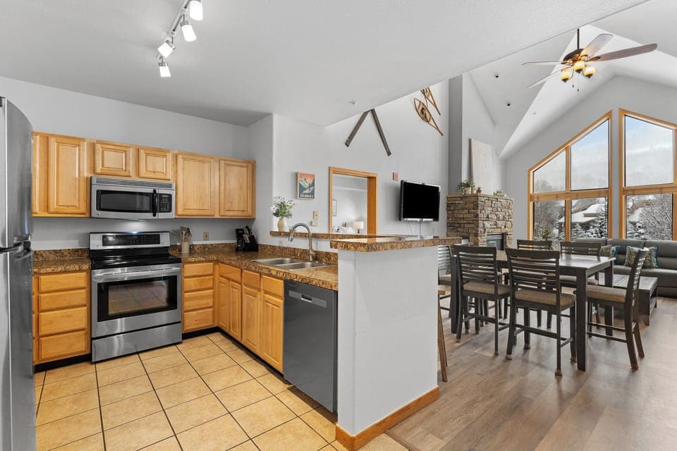 Full kitchen with stainless steel appliances and breakfast bar.