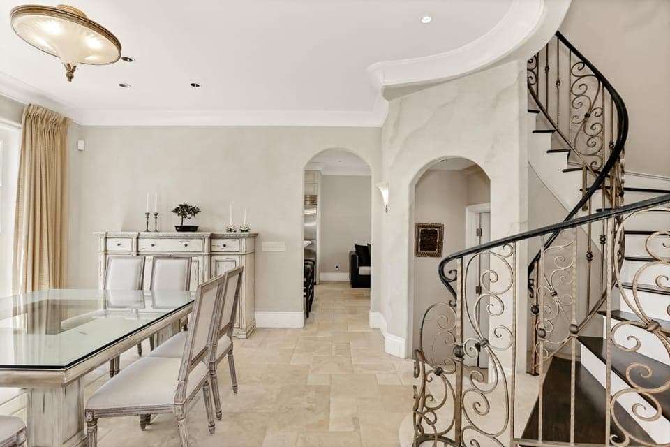 The intricate wrought iron spiral stair case, hand painted in black and gold leaf leads to the upper floors