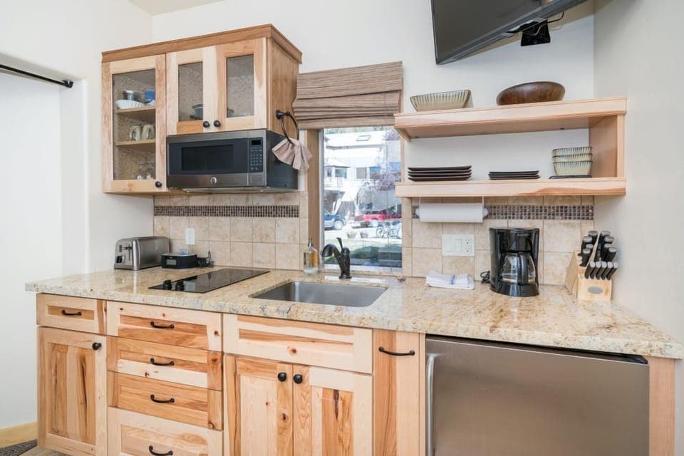 The 4th bedroom(100B) in its own studio space has a kitchenette with coffee maker and mini-fridge .