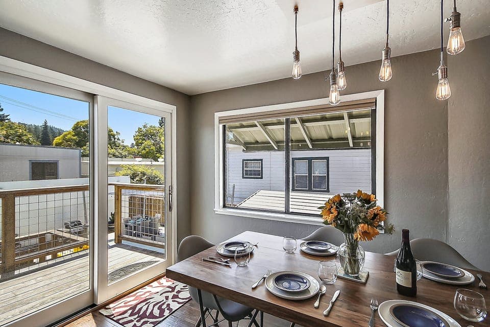 Light and bright dining space opens to the back stairs and overlooks the pool.