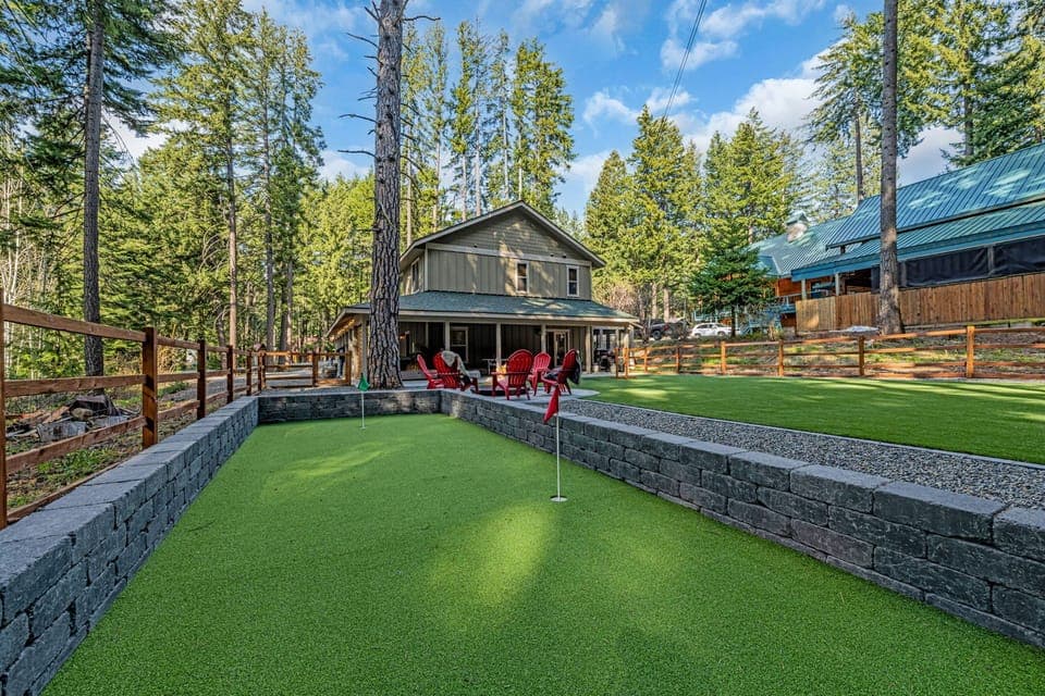 Fenced turf yard with putting green and bocce court