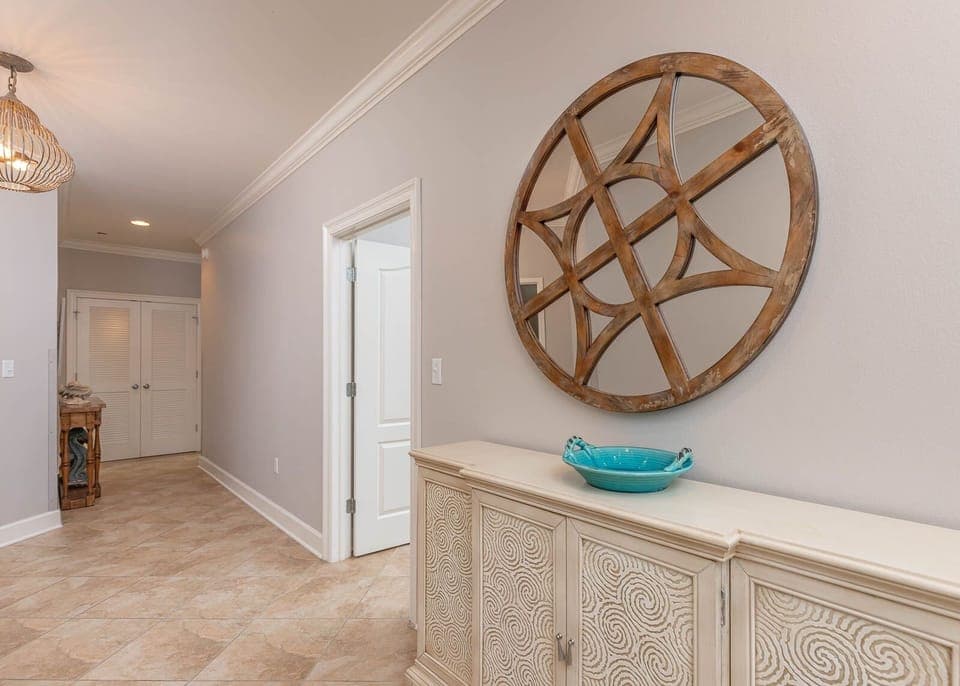 This hallway features elegant decor, including a decorative mirror and a stylish cabinet, enhancing your arrival experience