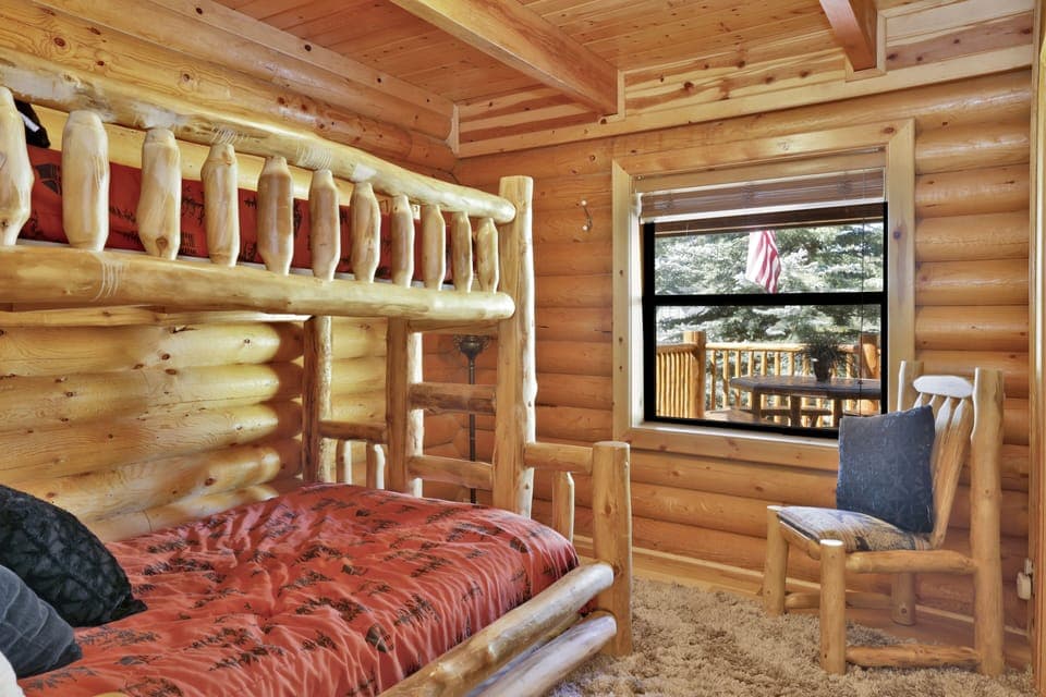 Peaceful cabin bedroom with plush bedding, and beautiful views—ideal for restful nights, cozy mornings, and a relaxing mountain escape.
