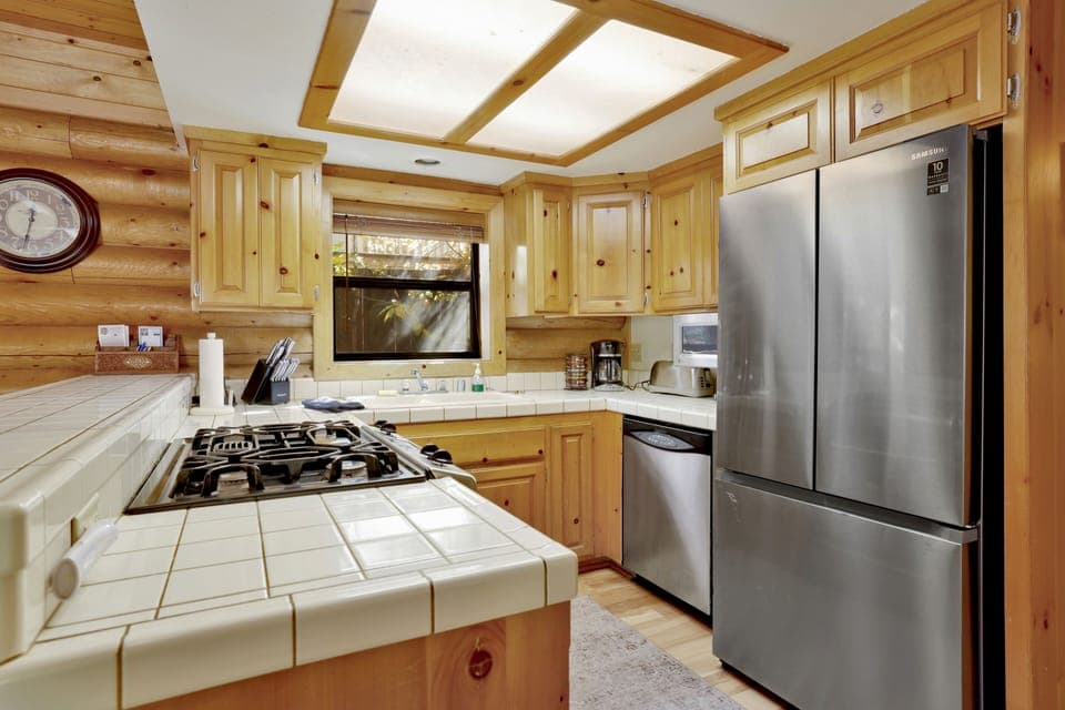Fully equipped cabin kitchen with ample cabinetry, stove, fridge, microwave, and coffee maker—perfect for cooking meals, morning coffee, and feeling right at home on your stay.