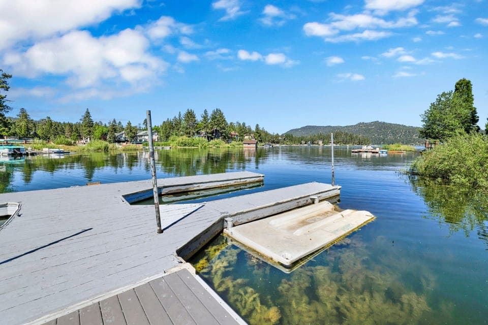 Scenic lakeside outdoor area with BBQ grills, picnic tables, and stunning water views—perfect for cookouts, relaxing afternoons, and unforgettable stays surrounded by nature.