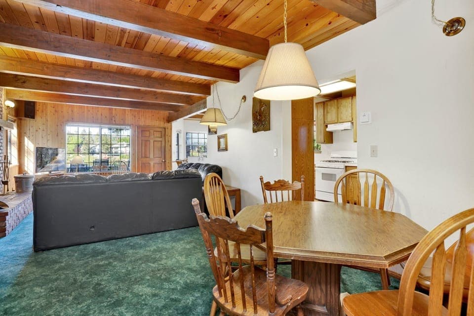 Fully equipped cabin kitchen with warm wood cabinets,stove, fridge, microwave, and coffee maker—perfect for cooking meals, morning coffee, and feeling right at home on your stay.