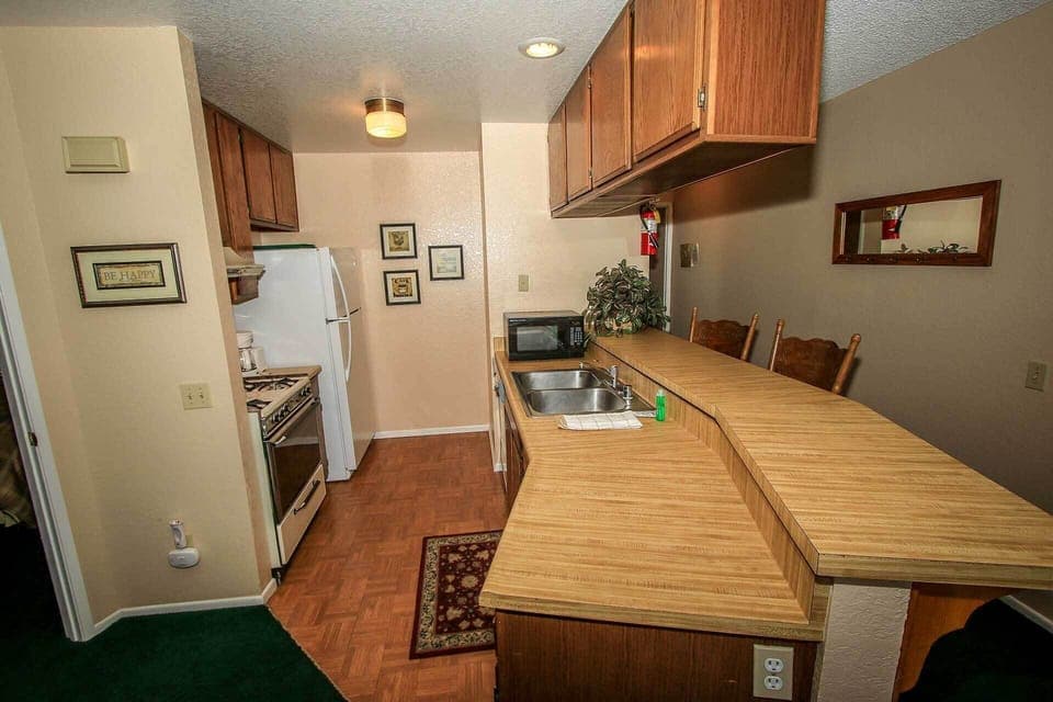 A practical kitchen layout featuring ample counter space, essential appliances, and a breakfast bar. Whether cooking a full meal or grabbing a quick snack, this space has everything you need for a comfortable stay.