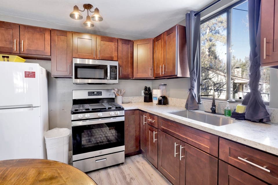 Kitchen with a refrigerator, stove, microwave, oven,blender, coffee machine, and a dining table to enjoy a delicious meal.