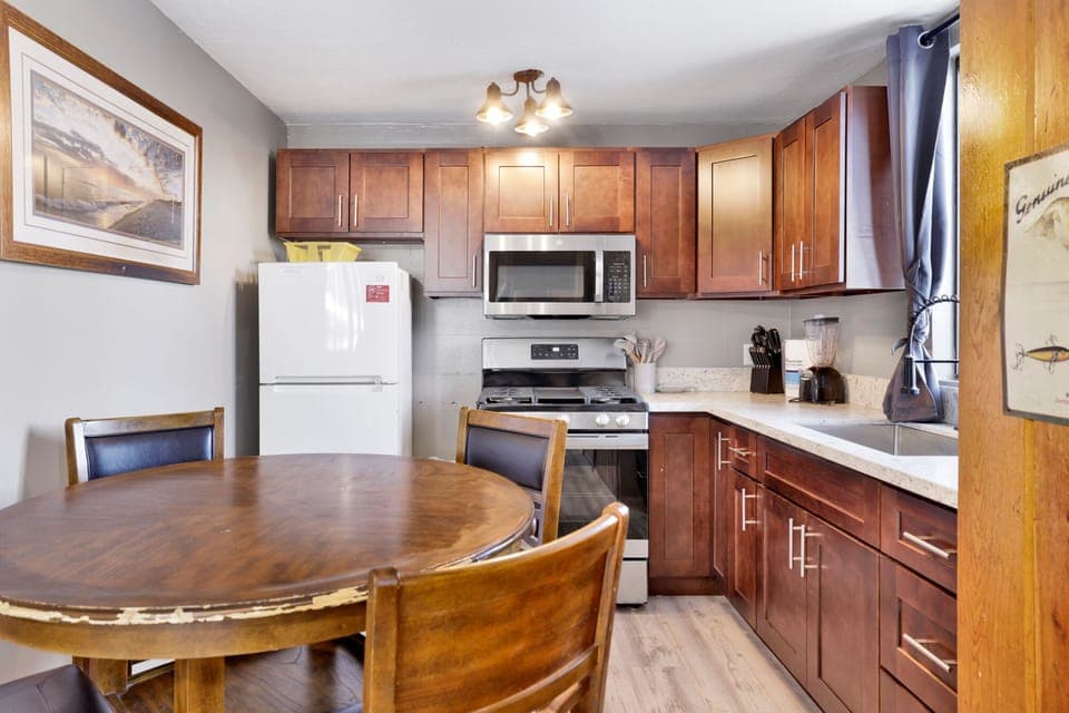 Kitchen with a refrigerator, stove, microwave, oven,blender, coffee machine, and a dining table to enjoy a delicious meal.