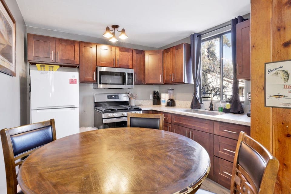 Kitchen with a refrigerator, stove, microwave, oven,blender, coffee machine, and a dining table to enjoy a delicious meal.